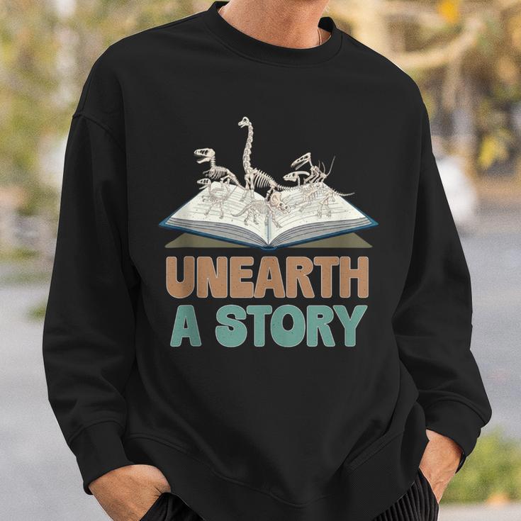 Unearth A Story Skeleton Dinosaur Book Summer Reading 2026 Sweatshirt Gifts for Him Unearth A Story Skeleton Dinosaur Book Summer Reading 2026 Sweatshirt Gifts for Him