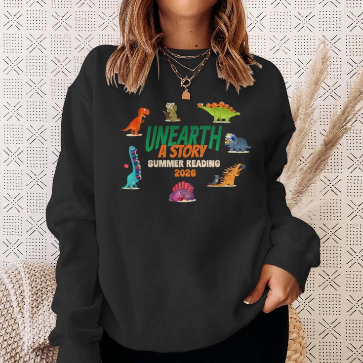 Summer Reading 2026 Unearth A Story Dinosaurs Book Lover Sweatshirt Gifts for Her Summer Reading 2026 Unearth A Story Dinosaurs Book Lover Sweatshirt Gifts for Her