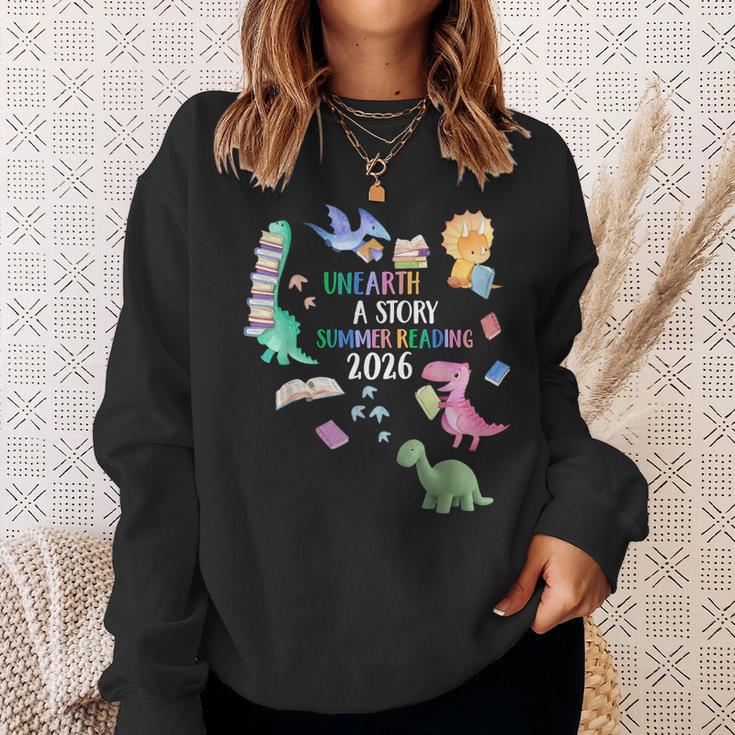Unearth a Story Dinosaur Book 2026 Summer Reading Program Sweatshirt Gifts for Her Unearth a Story Dinosaur Book 2026 Summer Reading Program Sweatshirt Gifts for Her