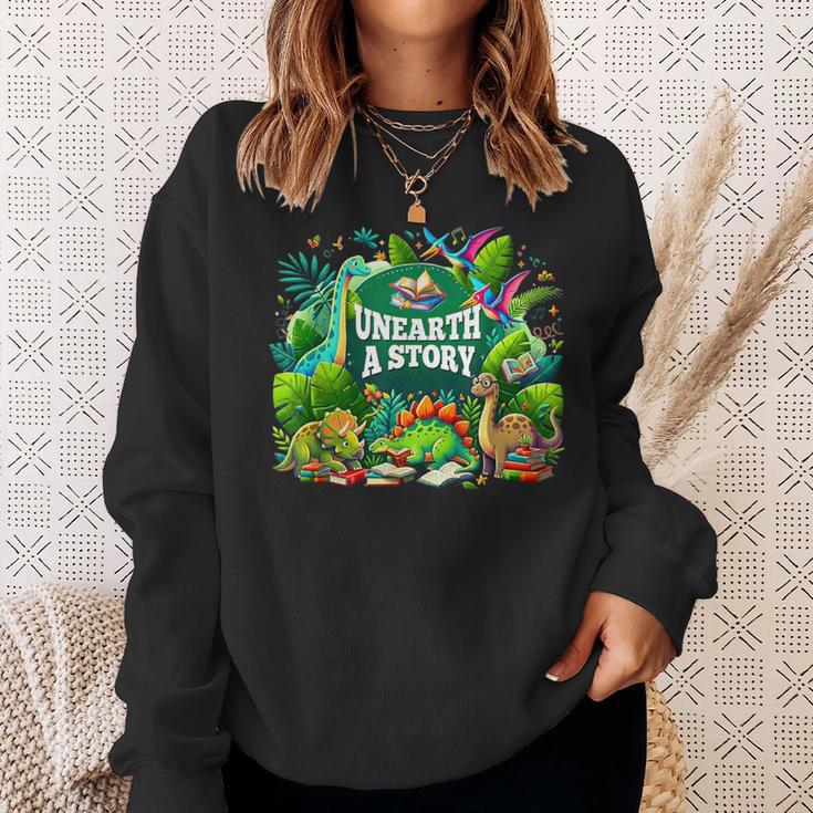 Unearth a Story Library Summer Reading 2026 Dinosaur Book Sweatshirt Gifts for Her Unearth a Story Library Summer Reading 2026 Dinosaur Book Sweatshirt Gifts for Her