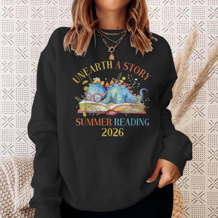 Unearth a Story Summer Reading 2026 Dinosaur Books Dino Sweatshirt Gifts for Her Unearth a Story Summer Reading 2026 Dinosaur Books Dino Sweatshirt Gifts for Her