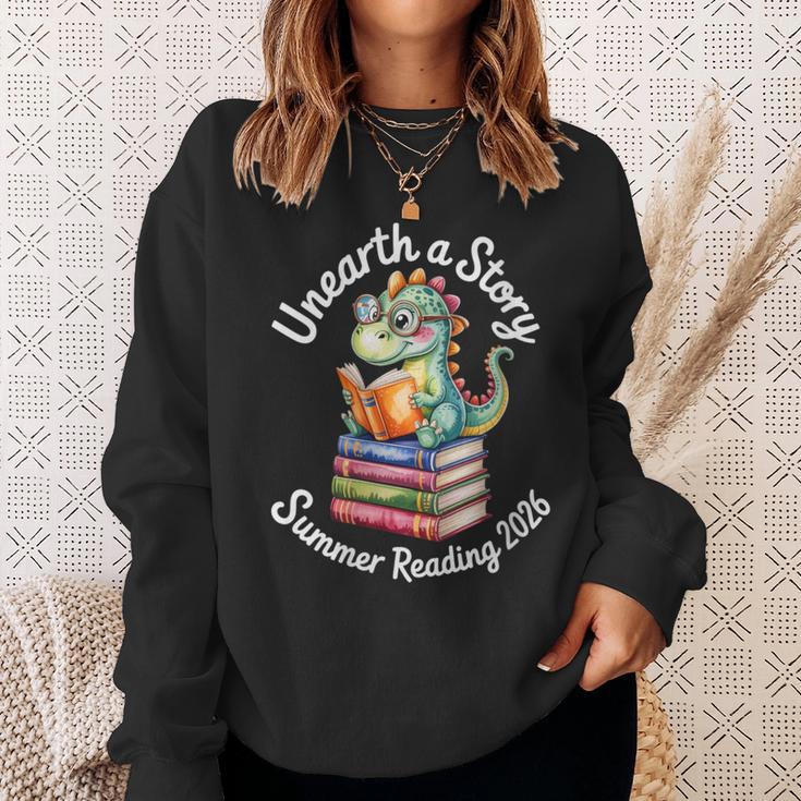 Women's Unearth a Story Summer Reading 2026 Book Lover Dino Fun Sweatshirt Gifts for Her Women's Unearth a Story Summer Reading 2026 Book Lover Dino Fun Sweatshirt Gifts for Her
