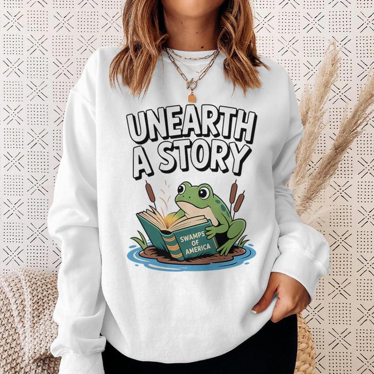 Unearth a Story Frog Reading a Book Summer 2026 Premium Tri-Blend Sweatshirt Gifts for Her