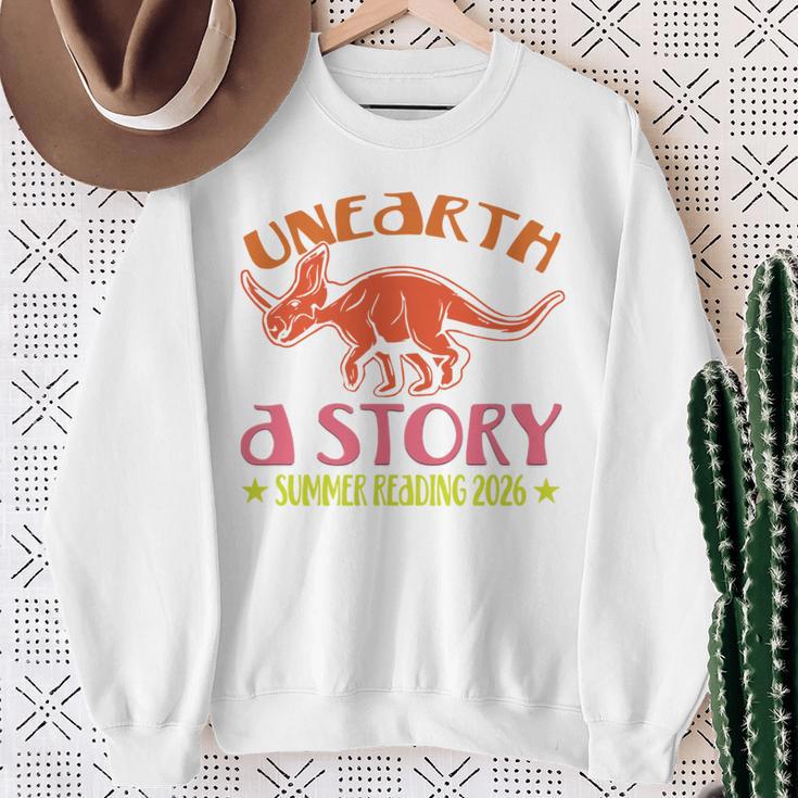 Unearth a Story Summer Reading 2026 Triceratops Dino Book Sweatshirt Gifts for Old Women Unearth a Story Summer Reading 2026 Triceratops Dino Book Sweatshirt Gifts for Old Women