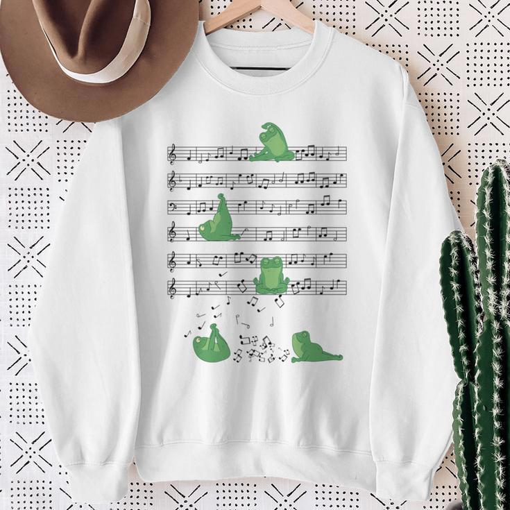 ヨガをしているかわいいカエル 音符 音記号 ミュージシャンアート 長袖tシャツ スウェットシャツ 年配の女性への贈り物