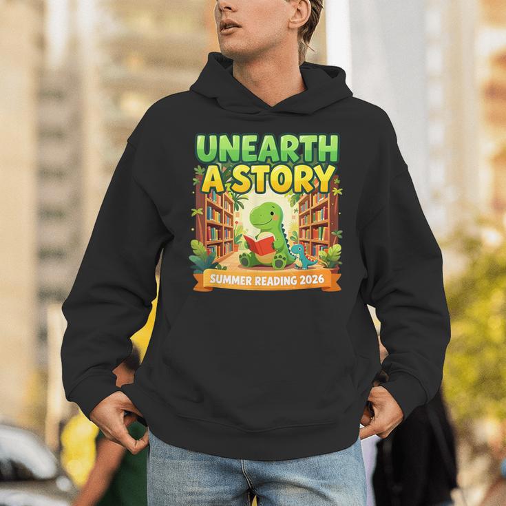 Unearth A Story Dinosaur Summer Reading 2026 Books Unisex Hoodie Unearth A Story Dinosaur Summer Reading 2026 Books Unisex Hoodie