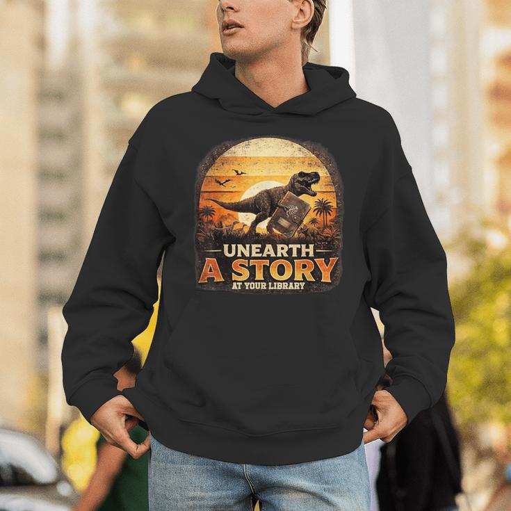 Unearth Story Summer Reading 2026 Dinosaurs Library Reading Unisex Hoodie Unearth Story Summer Reading 2026 Dinosaurs Library Reading Unisex Hoodie