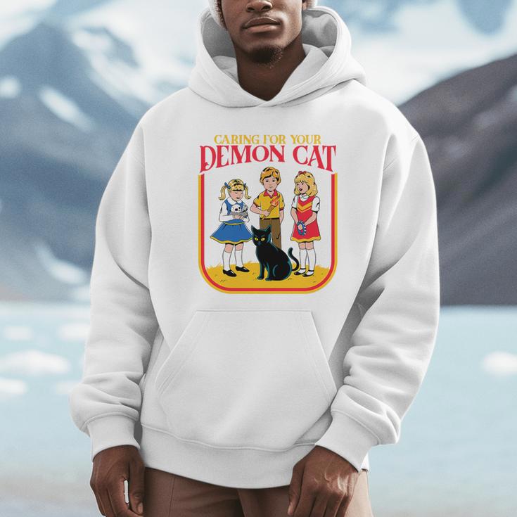 Caring For Your Evil Cat Retro Dark Humor Book Cover Premium Tri-Blend Unisex Hoodie
