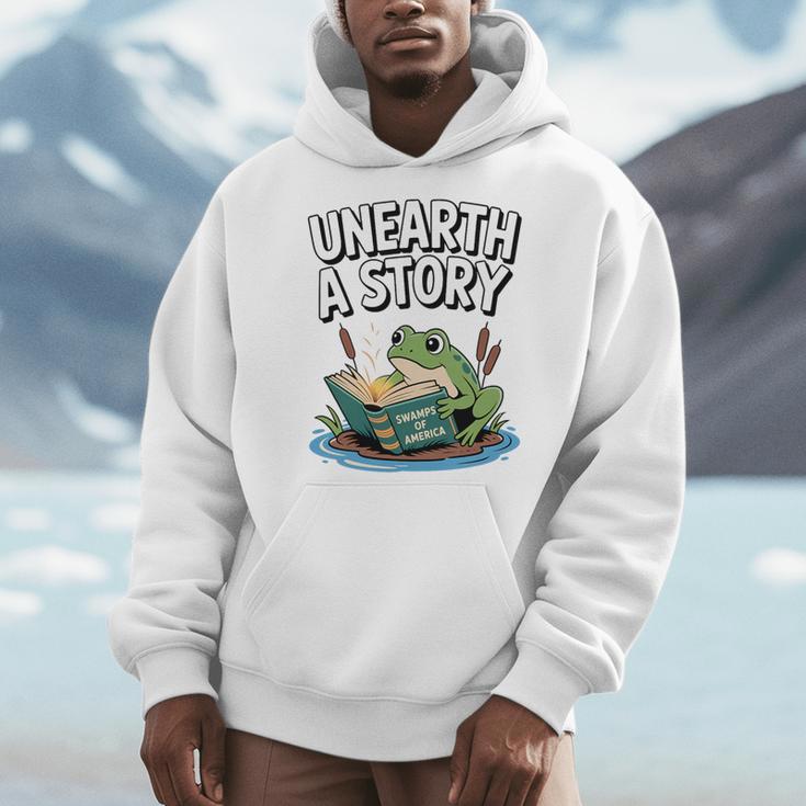 Unearth a Story Frog Reading a Book Summer 2026 Premium Tri-Blend Men Hoodie