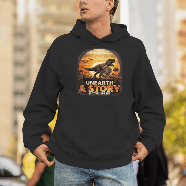 Unearth Story Summer Reading 2026 Dinosaurs Library Reading Men Hoodie Unearth Story Summer Reading 2026 Dinosaurs Library Reading Men Hoodie