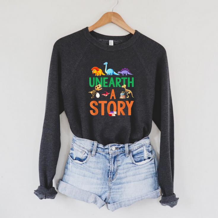 Summer Reading 2026 Dinosaurs Book Lover Unearth A Story Raglan Sleeve Sweatshirt