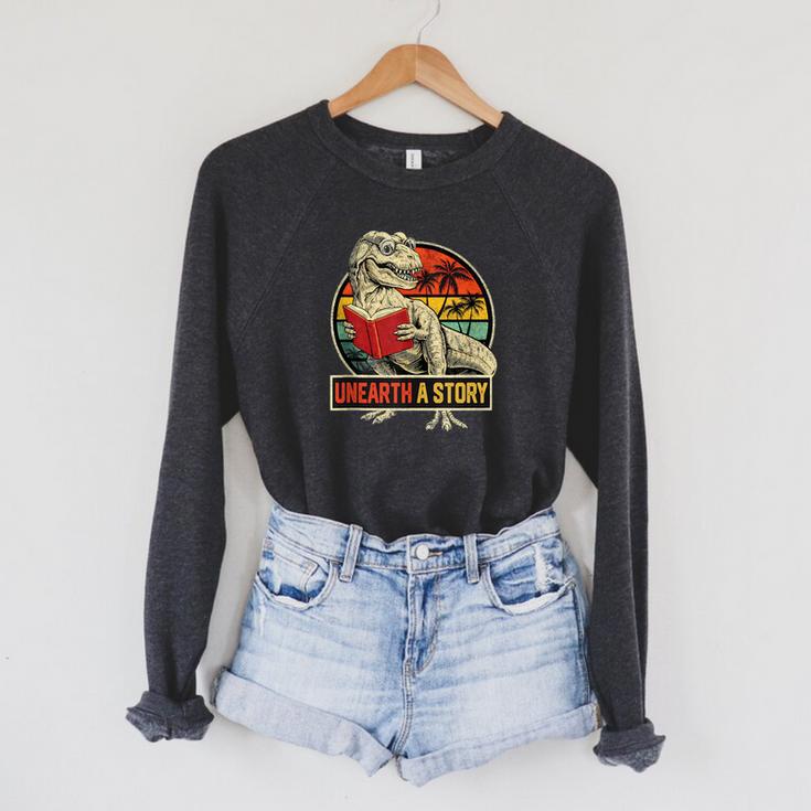 Unearth a Story Dinosaur Reading Book Dino T Rex Summer 2026 Raglan Sleeve Sweatshirt