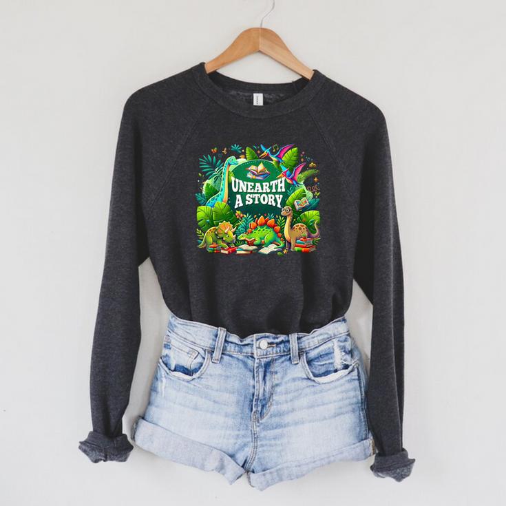 Unearth a Story Library Summer Reading 2026 Dinosaur Book Raglan Sleeve Sweatshirt