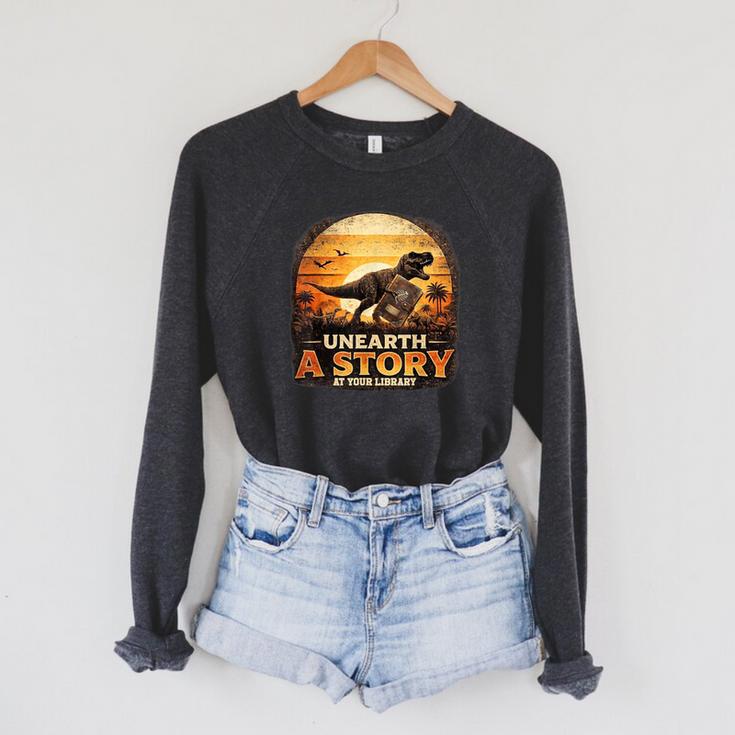 Unearth Story Summer Reading 2026 Dinosaurs Library Reading Raglan Sleeve Sweatshirt