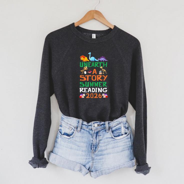 Unearth A Story Summer Reading Program 2026 Dinosaur Book Raglan Sleeve Sweatshirt