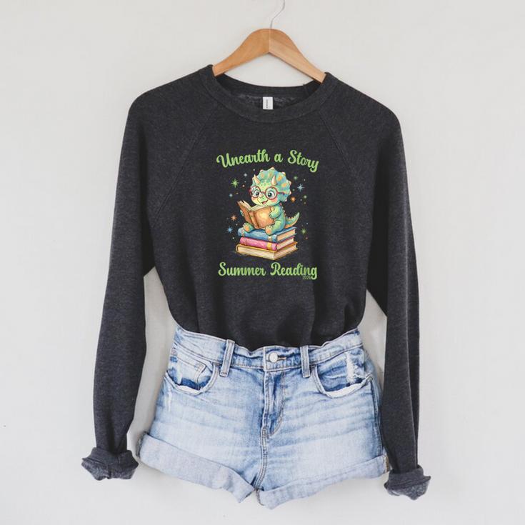 Women's Unearth a Story Triceratops Dinosaur Reading Books Cute Dino Raglan Sleeve Sweatshirt