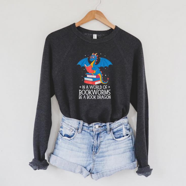In A World Full Of Bookworms Be A Book Dragon Reading Raglan Sleeve Sweatshirt