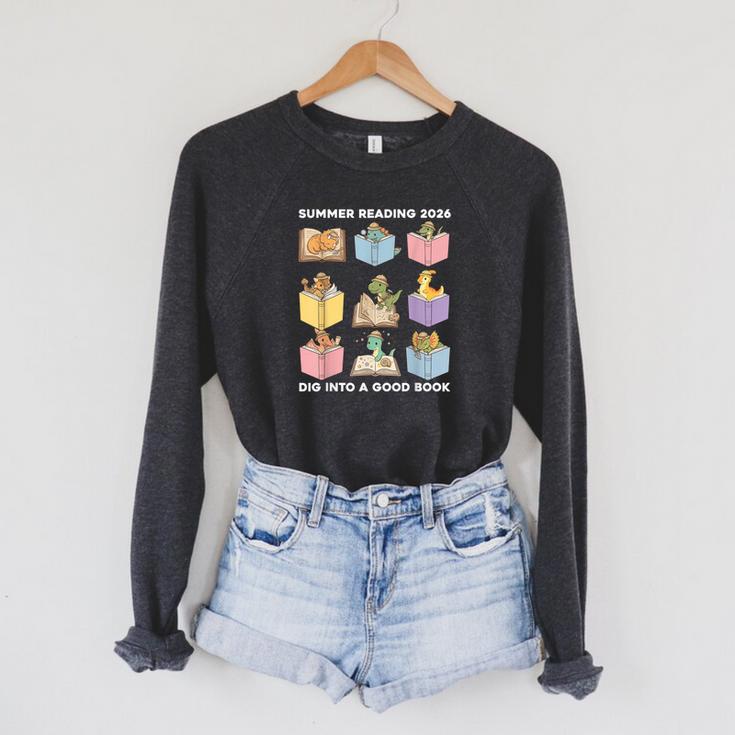 Summer Reading 2026 Unearth A Story Dinosaur Books Readers Raglan Sleeve Sweatshirt Summer Reading 2026 Unearth A Story Dinosaur Books Readers Raglan Sleeve Sweatshirt