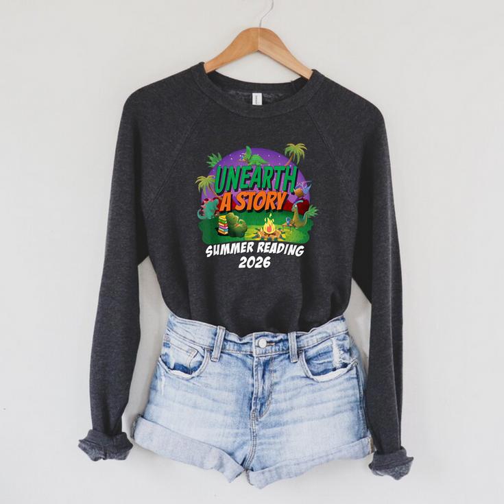 Unearth a Story Summer Reading 2026 Dinosaur T-Rex Book Raglan Sleeve Sweatshirt