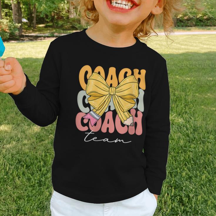 Coach Team Groovy Coquette Bow Cute Back To School Graphic Toddler Long Sleeve Tee Coach Team Groovy Coquette Bow Cute Back To School Graphic Toddler Long Sleeve Tee