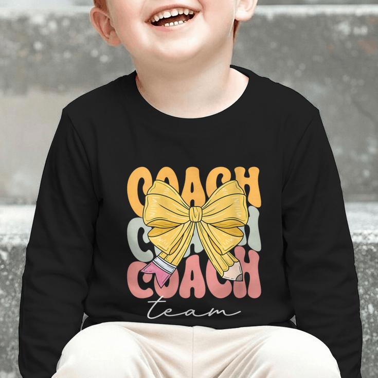 Coach Team Groovy Coquette Bow Cute Back To School Graphic Toddler Long Sleeve Tee Coach Team Groovy Coquette Bow Cute Back To School Graphic Toddler Long Sleeve Tee