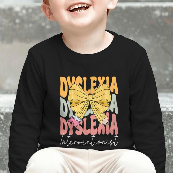 Dyslexia Interventionist Groovy Coquette Bow Back To School Graphic Toddler Long Sleeve Tee Dyslexia Interventionist Groovy Coquette Bow Back To School Graphic Toddler Long Sleeve Tee