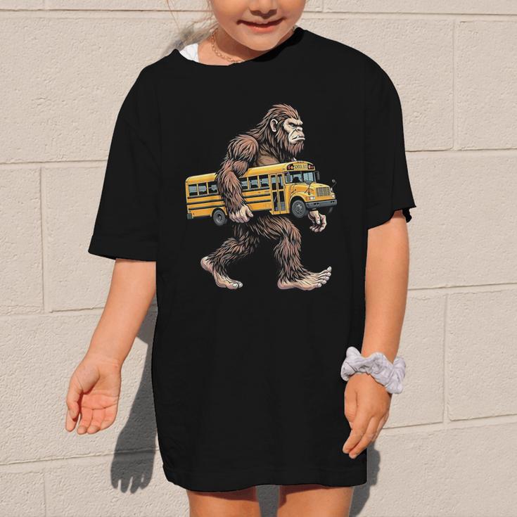 Bigfoot Carrying School Bus Sasquatch Back To School Graphic Kid T-Shirt Bigfoot Carrying School Bus Sasquatch Back To School Graphic Kid T-Shirt