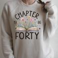 1986 Chapter Forty 40th Birthday Wildflower Book 40 Year Old Raglan Sleeve Sweatshirt Heather Forest 1986 Chapter Forty 40th Birthday Wildflower Book 40 Year Old Raglan Sleeve Sweatshirt Heather Forest