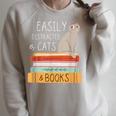 Easily Distracted Cats And Books Cat Lovers For Men Women Kids Raglan Sleeve Sweatshirt Heather Forest