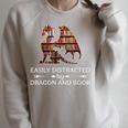 Easily Distracted By Dragon And Book Apparel Raglan Sleeve Sweatshirt Heather Forest
