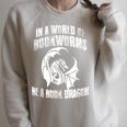 In A World Of Bookworms Be A Book Dragon Inspirational Raglan Sleeve Sweatshirt Heather Forest