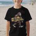 Bigfoot Carrying School Bus Sasquatch Back To School Graphic Kid T-Shirt Bigfoot Carrying School Bus Sasquatch Back To School Graphic Kid T-Shirt